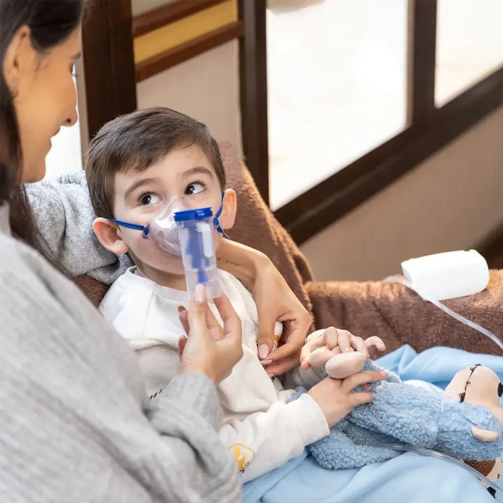 Imagem ambientada da modelo com uma criança pequena utilizando nebulizador