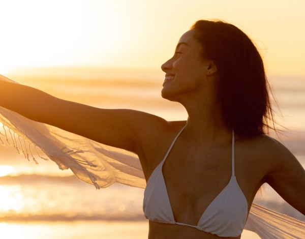 Mulher de bikini branco com uma praia ao fundo